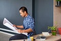 Focused young Asian architect reading blueprints in an office Royalty Free Stock Photo