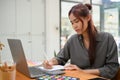 Focused young asian female graphic designer sketching her design on blank notebook Royalty Free Stock Photo