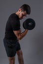 Focused young man performing dumbbell bicep curl Royalty Free Stock Photo