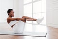 Focused Young Black Woman Doing Crunches Exercise On Yoga Mat