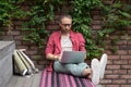 Focused young businessman freelancer engaged in distant work from street make report on laptop