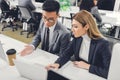 Focused young businesspeople discussing work and pointing at laptop Royalty Free Stock Photo