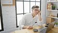 Focused young caucasian businessman thinking hard at office desk, his intense stare fixed on laptop screen