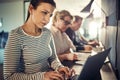 Focused young designer sitting with office colleagues using a la