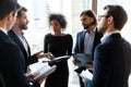 Focused young diverse business people discussing project ideas in circle. Royalty Free Stock Photo