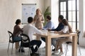 Focused young diverse employees listening to older 60s team leader. Royalty Free Stock Photo