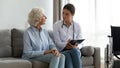 Focused young doctor listening to older mature patient complaints.