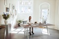 Focused young female architect working on designs at her desk Royalty Free Stock Photo