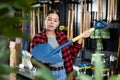 Focused young woman choosing a new shovel for gardening in a hardware store Royalty Free Stock Photo