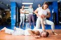 Young hispanic woman mastering hammerlock on male opponent in self defence training in gym