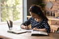 Focused young latin woman in headphones engaged in e learning Royalty Free Stock Photo