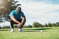 That was so close. a focused young male golfer looking at the ground while being seated on the grass outside during the Royalty Free Stock Photo