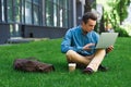 focused young man using laptop and sitting