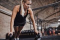 Focused young woman doing pushups with weights in a gym Royalty Free Stock Photo