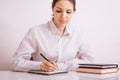 Focused young woman entrepreneur deep in thought, working at table writes notes Royalty Free Stock Photo