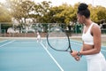 Focused young woman playing tennis with her friend. African american woman competing in a game of tennis. Professional