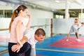 Girl practicing elbow and knee strikes with arm hold to male sparring partner at gym Royalty Free Stock Photo