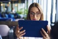 Focused, young woman using tablet