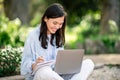 Focused young woman working on laptop in natural setting Royalty Free Stock Photo