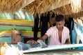 Focussed african american man preparing surfboard behind counter of surf hire beach shack Royalty Free Stock Photo