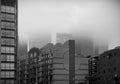 Fog in the city. Black and white image of high-rise buildings capped with thick fog on a rainy cloudy day. Royalty Free Stock Photo