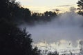 Fog before dawn on a forest lake