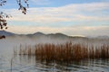 Fog growing on quiet lake waters landscape in Banyoles, Catalonia