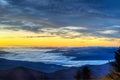 Fog lies over the mountains and yellow highlights the sky in the Smokies. Royalty Free Stock Photo