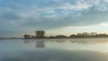 Fog over a calm lake, trees on the horizon Royalty Free Stock Photo