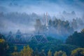 Fog over city and trees. earlier morning over village. railway bridge in fog