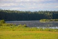 Fog over lake in the early morning. Green field and forest under a cloudy sky Royalty Free Stock Photo