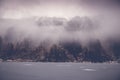 Fog over the lake overlooking the mountain with forest. Beautiful autumn landscape Royalty Free Stock Photo