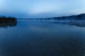 Fog over the lake, twilight over the lake, very dense fog, dawn, blue sky over the lake, the morning comes, the forest reflects in Royalty Free Stock Photo