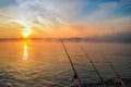 River sunrise landscape - fishing sunrise and fog on the water - fishing rods at sunrise on the river shore - Danube river Romania Royalty Free Stock Photo