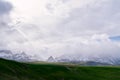 Fog over snow-capped mountains descends onto a green valley Royalty Free Stock Photo