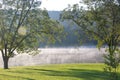 Fog rising off lake on a cold sunny morning. Royalty Free Stock Photo