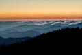 Fog rolls in below colorful sunset in the Smoky Moutnains.