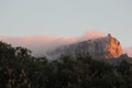 Fog streaming down tablemountain, reddish sunset mood Royalty Free Stock Photo