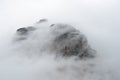 Fog surrounds a mountain peak in Glacier National Park. Royalty Free Stock Photo