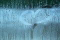 Fogged up glass with painted heart with many drops, close up