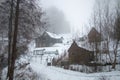 Old wooden cabin with trees in background in deep fog