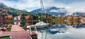 Foggy autumn view of Grundlsee lake with small yacht. Amazing morning scene of Brauhof village, Styria stare of Austria, Europe.