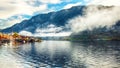 Foggy autumnal sunrise at famous Hallstatt lakeside town reflect