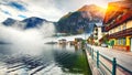 Foggy autumnal sunrise at famous Hallstatt lakeside town reflect Royalty Free Stock Photo