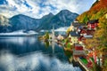 Foggy autumnal sunrise at famous Hallstatt lakeside town reflect Royalty Free Stock Photo