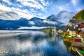 Foggy autumnal sunrise at famous Hallstatt lakeside town reflect Royalty Free Stock Photo