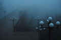 foggy bridge with lanterns in the autumn morning in mystical fog mist