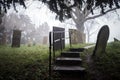 Foggy eerie graveyard mist creepy fog around headstones grave stones peaceful atmosphere old abandoned derelict English church Royalty Free Stock Photo