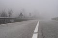 Foggy empty highway road with low visibility