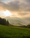 Foggy epic sunrise countryside panorama, valley, hills, field, forest, sun breaking through the clouds